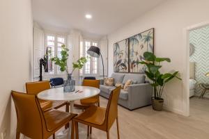 sala de estar con mesa, sillas y sofá en Thyssen Boutique Apartments by Caleta Homes en Málaga