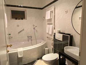 a bathroom with a tub and a toilet and a sink at Apartments Villa Majda in Matulji