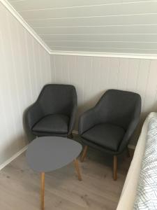 dwa krzesła i stół w pokoju z łóżkiem w obiekcie MAYS Apartment w mieście Mysen
