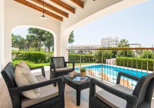 un patio avec des chaises et une table à côté d'une piscine dans l'établissement Villa Evita, à Santo Tomas