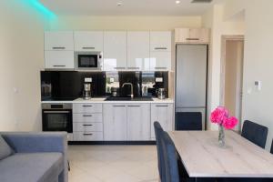 a kitchen with white cabinets and a table with a vase of flowers at Gramvoussa Bay in Kissamos