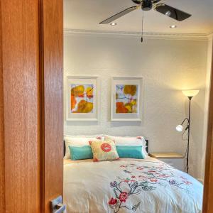 - une chambre avec un lit et deux photos sur le mur dans l'établissement Cozy and stylish 3 bedroom home in Mentone, à Mentone