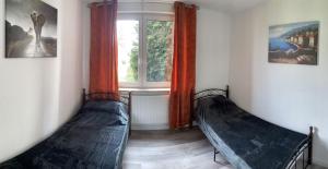two beds in a room with a window at MRS in Hürth
