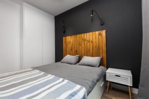 グダニスクにあるUroczy Apartament w Sercu Starego Miastaのベッドルーム1室(ベッド1台、木製ヘッドボード付)