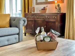 una caja de vino en una mesa en la sala de estar en Rye Court Cottage - Stunning cottage in central Helmsley with parking en Helmsley