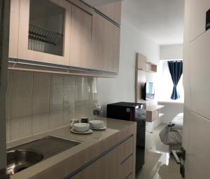 a kitchen with a sink and a counter top at Apartment Grand Sentraland Karawang Manage by Laguna Room in Karawang