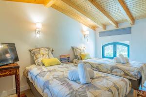 two beds in a room with a tv at Villa Jade in Colares +39 photos