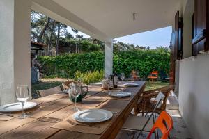 a wooden table with plates and wine glasses on a patio at Villa Jade in Colares