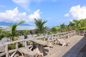 a wooden bridge over a beach with palm trees at Ban Sulada Guest House in Laem Ngop
