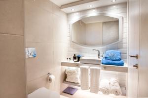 a bathroom with a sink and a mirror and towels at Acrotel Lily Ann Village in Nikiti +37 photos