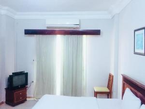 a bedroom with a bed and a window with a television at Hurghada Dreams in Hurghada