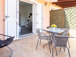 a patio with a table and chairs and a door at SweetHome - MORADA in Torpè