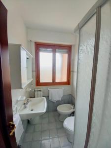 a bathroom with two sinks and a toilet and a window at Residence Cherie in Borgio Verezzi