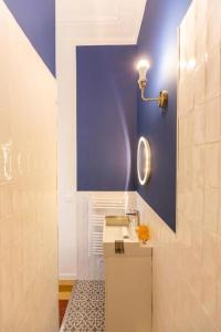 ein Badezimmer mit einem Waschbecken und einer blauen Wand in der Unterkunft GARE ST Charles - VIEUX PORT - T4 D'EXCEPTION in Marseille
