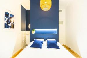 - une chambre avec un lit blanc aux murs bleus dans l'établissement 3 min à pied de la gare St Charles - 3 chambres avec Clim, SDB et TV, à Marseille