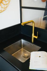 a stainless steel sink with a faucet and a paper at Alaena, vue imprenable sur l'océan in Biarritz
