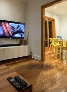 uma sala de estar com uma televisão e uma mesa e cadeiras em Cozy and stylish 3 bedroom home in Mentone em Mentone