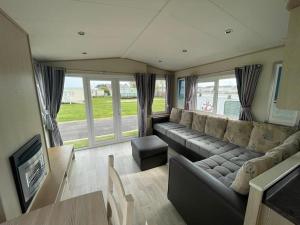 a living room with a couch and a tv at PG177 Golden Palm Resort 8 Berth Caravan With Decking in Chapel Saint Leonards