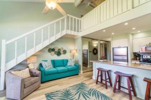 a living room with a blue couch and a kitchen at Papakea K406 OceanView 2 Bedroom 2 bath condo in Kahana