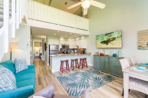 a living room with a blue couch and a kitchen at Papakea K406 OceanView 2 Bedroom 2 bath condo in Kahana