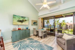 a living room with a table and chairs and a ceiling fan at Papakea K406 OceanView 2 Bedroom 2 bath condo in Kahana