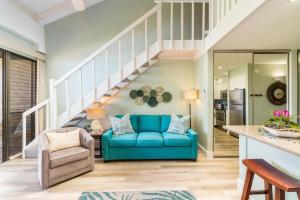 a living room with a blue couch and stairs at Papakea K406 OceanView 2 Bedroom 2 bath condo in Kahana +39 photos