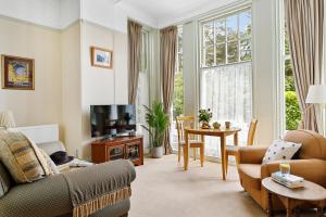 a living room with a couch and a tv at Vomero Holiday Apartments in Torquay