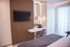 a bedroom with a bed and a desk on a wall at Pavlo Napa Beach Hotel in Ayia Napa