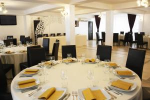 a dining room with a white table and chairs at Pensiunea Royal in Borşa