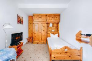 1 dormitorio con 1 cama y TV en Hotel Nuss, en Grainau