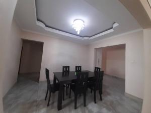 a dining room with a black table and chairs at Amariah Guesthouse - Kazungula in Kasane