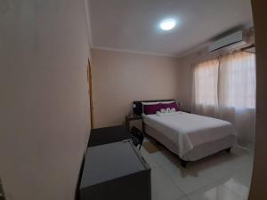 a bedroom with a bed and a table and a window at Amariah Guesthouse - Kazungula in Kasane