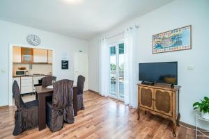 a living room with a dining room table and a tv at Apartments Nico in Dubrovnik