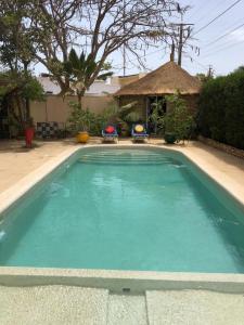 una piscina de agua azul en un patio en Agréable Villa LuLu sur la côte - La Somone, en Ngaparou