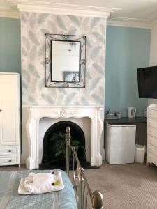 a living room with a fireplace and a bed at The Mayfair Hotel in Great Yarmouth