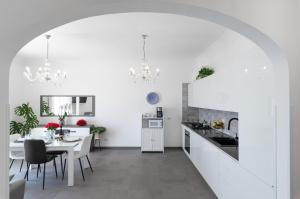 a kitchen and dining room with white walls and a table at Casa Clara in Praiano