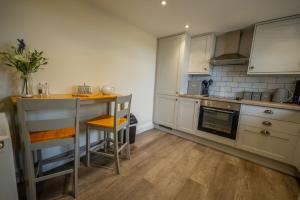 a kitchen with white cabinets and a counter top at The Stables in Halesworth