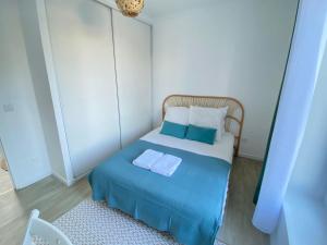 1 dormitorio pequeño con 1 cama azul y 2 almohadas en Appartement Gare de Meaux - Proche Disney /Paris, en Meaux