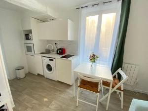 una cocina con una mesa y sillas blancas y una ventana en Appartement Gare de Meaux - Proche Disney /Paris, en Meaux