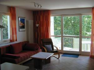 - un salon avec un canapé et une chaise dans l'établissement Zinnowitz Residenz Sanssouci, à Zinnowitz