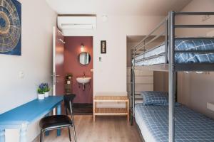 Jest to pokój wieloosobowy z łóżkiem piętrowym, biurkiem i łóżkiem piętrowym. w obiekcie Het Oplaadpunt: bed, bike, hike, 8-12 p. w mieście Diksmuide