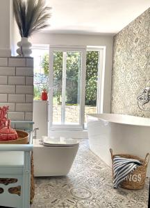 ein Bad mit einer weißen Badewanne und einem Fenster in der Unterkunft Casa di Campara in Neum