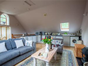 uma sala de estar com um sofá e uma mesa em Jasmine Cottage em Little Witcombe