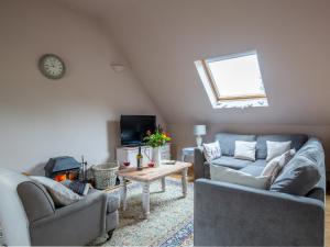 a living room with two couches and a table at Jasmine Cottage in Little Witcombe