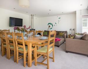 a dining room with a wooden table and chairs at The Wrens in Polzeath