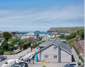 a white building with cars parked in a parking lot at The Wrens in Polzeath