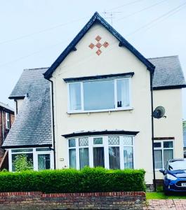 a white house with a window and a car at Bridlington Shore Apartment in Bridlington