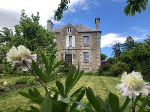 an old stone house with flowers in the foreground at La Maison Ruth in Montbray