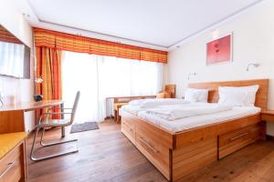 una camera con un grande letto e una scrivania di Hotel Zum Ochsen a Schönwald