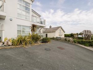an empty driveway in front of a white house at Tides in Benllech
